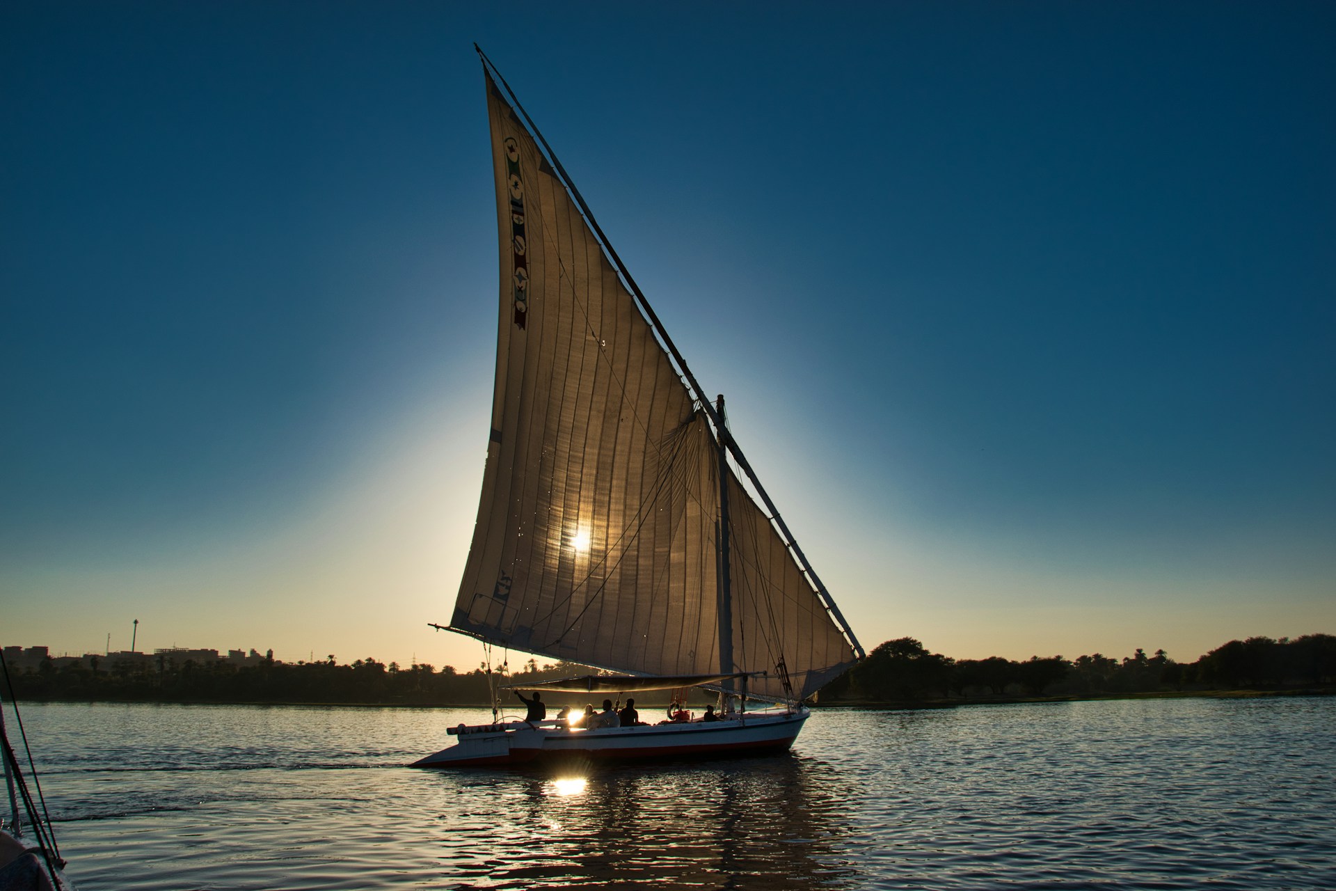 Felouque naviguant sur le Nil au coucher du soleil